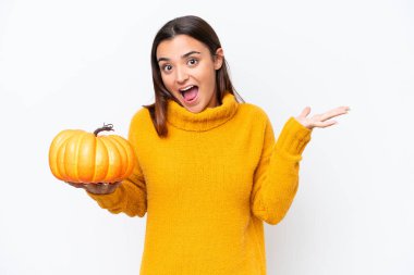 Beyaz arka planda kabak tutan beyaz kadın şok olmuş yüz ifadesi ile izole edildi.