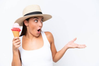 Kornet dondurması olan beyaz arka planda yüzü şaşırmış genç beyaz bir kadın.