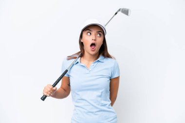 Beyaz arka planda izole bir şekilde golf oynayan beyaz bir kadın yukarı bakıyor ve şaşırmış bir ifadeyle