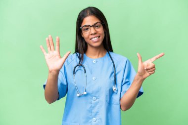 Genç Afrikalı Amerikalı hemşire, tecrit edilmiş arka planda yediyi parmaklarıyla sayıyor.