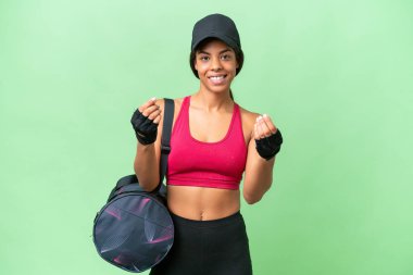 Spor çantasıyla izole edilmiş geçmişi olan genç Afrikalı Amerikalı kadın para hareketi yapıyor.