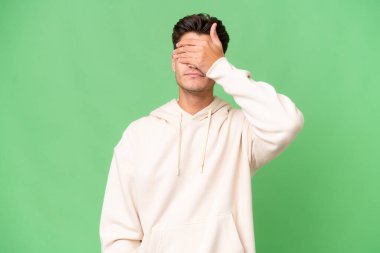 İzole edilmiş geçmişi olan beyaz, yakışıklı genç bir adam. Gözlerini elleriyle kapatıyor. Bir şey görmek istemiyorum.