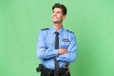 İzole edilmiş bir geçmişi olan genç bir polis gülümserken yukarı bakıyor.