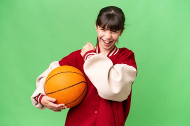 İzole edilmiş arka planda basketbol oynayan küçük beyaz kız zaferi kutluyor.