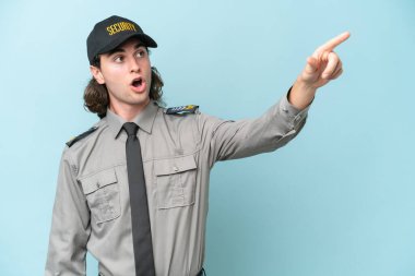 Genç güvenlik görevlisi mavi arka planda izole edilmiş.