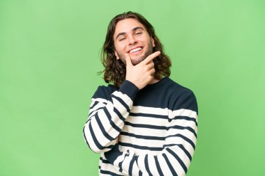 Soyutlanmış, mutlu ve gülümseyen genç ve yakışıklı bir adam.