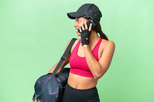 若いスポーツアフリカ系アメリカ人女性スポーツバッグとの隔離された背景に誰かと携帯電話との会話を保つ — ストック写真