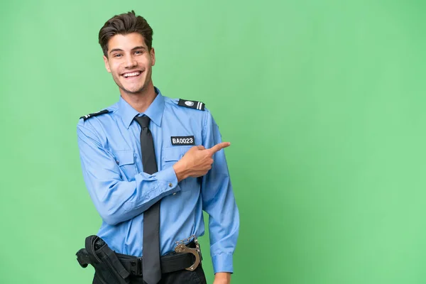 Młody Policjant Odizolowanym Tle Wskazując Palcem Bok — Zdjęcie stockowe
