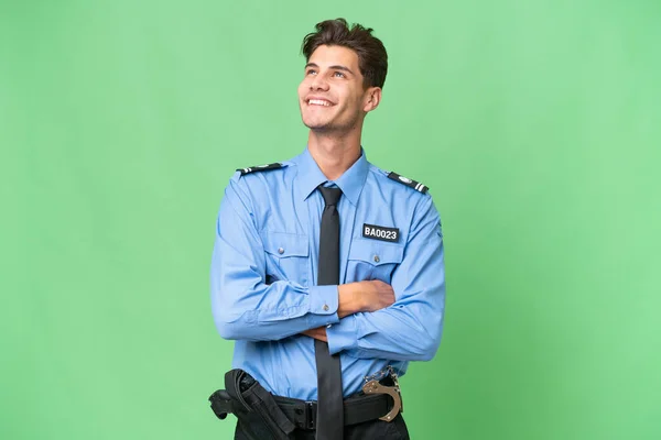 Joven Policía Sobre Fondo Aislado Mirando Hacia Arriba Mientras Sonríe — Foto de Stock