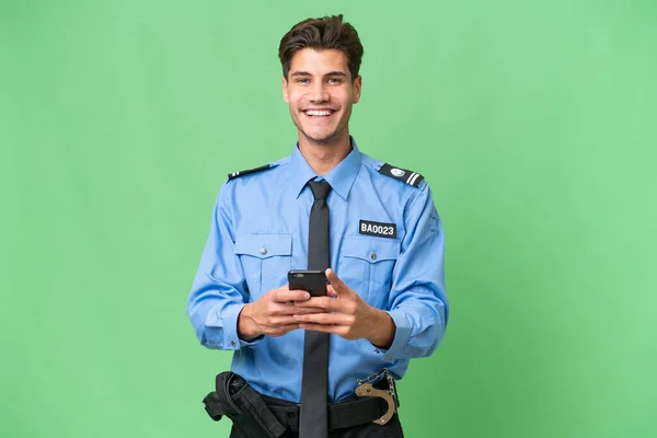 Jovem Policial Sobre Fundo Isolado Enviando Uma Mensagem Com Celular — Fotografia de Stock