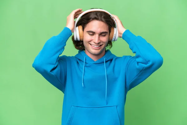 Jonge Knappe Man Geïsoleerd Groene Chroma Achtergrond Luisteren Muziek — Stockfoto