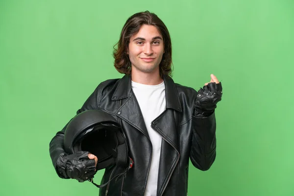 若いですハンサムな男とともにオートバイヘルメット隔離上の緑クロマ背景作るお金ジェスチャー — ストック写真