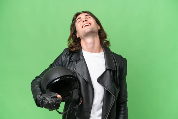 若いですハンサムな男とともにオートバイヘルメット隔離上の緑色の背景笑い — ストック写真