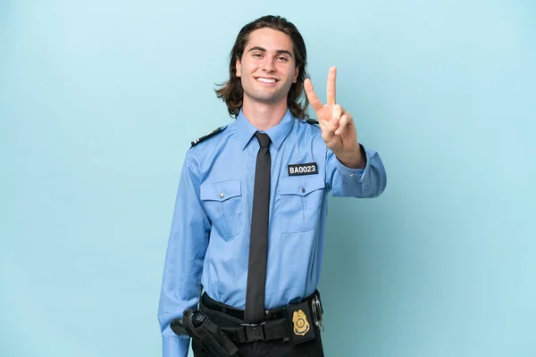 Joven Policía Caucásico Hombre Aislado Sobre Fondo Azul Sonriendo Mostrando —  Fotos de Stock