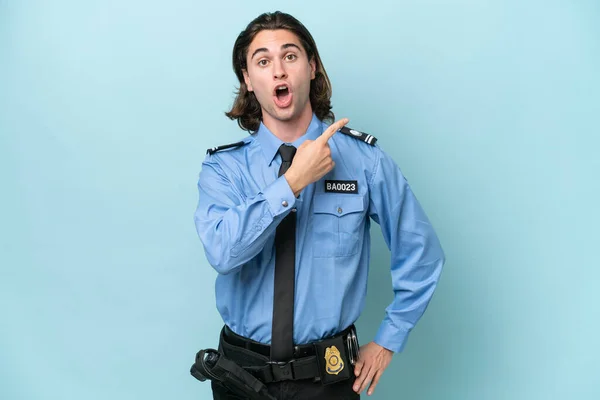 Młody Policja Kaukaski Człowiek Odizolowany Niebieski Tło Zaskoczony Wskazując Strony — Zdjęcie stockowe