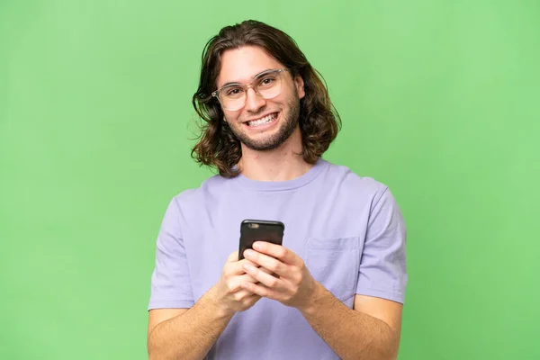 年轻帅气的男子从孤立的背景发送一个消息与手机 — 图库照片