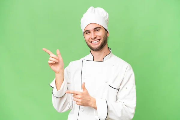 Jonge Knappe Chef Kok Geïsoleerde Achtergrond Wijzende Vinger Naar Zijkant — Stockfoto