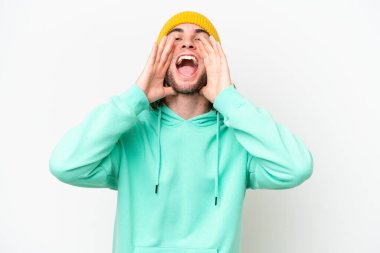 Genç yakışıklı adam beyaz krom arka planda izole edilmiş bağırıyor ve bir şey duyuruyor.