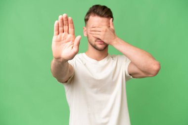 Sarışın, beyaz, soyutlanmış bir geçmişi olan genç bir adam jesti durdurup yüzünü kapatıyor.