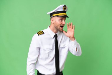 Uçak pilotu izole edilmiş arka planda ağzı sonuna kadar açık bağırıyor.