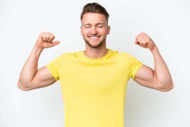 Beyaz arka planda izole genç sarışın beyaz adam güçlü bir jest yapıyor.