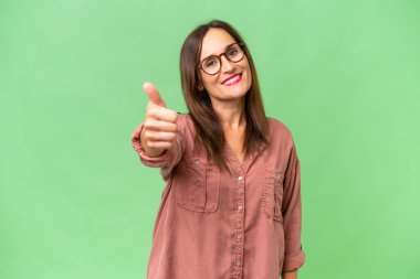 Orta yaşlı beyaz kadın, soyutlanmış bir geçmişi var. Başparmakları havada. Çünkü iyi bir şey oldu.