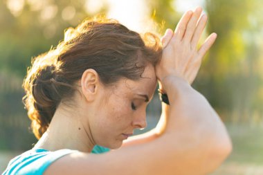 Dışarıda yoga yapan genç bir kadın.