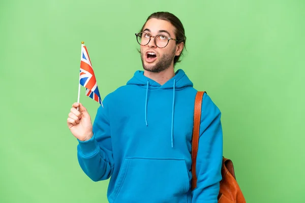 Mladý Pohledný Muž Drží Britskou Vlajku Nad Izolovaným Pozadím Překvapeným — Stock fotografie