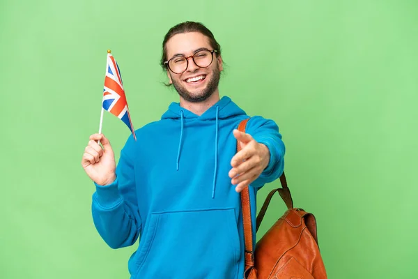 年轻英俊的男子举着英国国旗 举着孤立的背景音乐 握手表示要把许多东西合拢在一起 — 图库照片