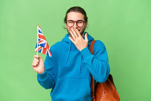 年轻英俊的男子举着英国国旗 在与世隔绝的背景下快乐地微笑着 用手捂着嘴 — 图库照片