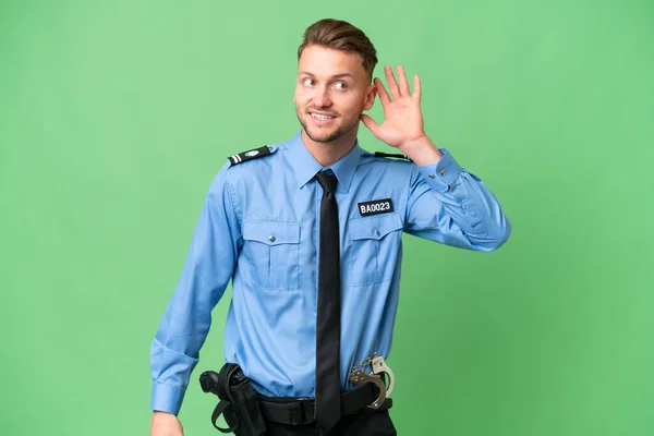 Młody Policjant Odosobnionym Pochodzeniem Słucha Czegoś Przykładając Rękę Ucha — Zdjęcie stockowe