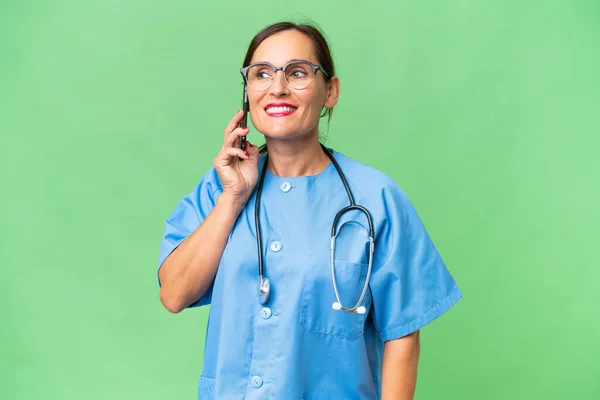 Pielęgniarka Średnim Wieku Odosobnionym Otoczeniu Rozmawiająca Przez Telefon Komórkowy — Zdjęcie stockowe