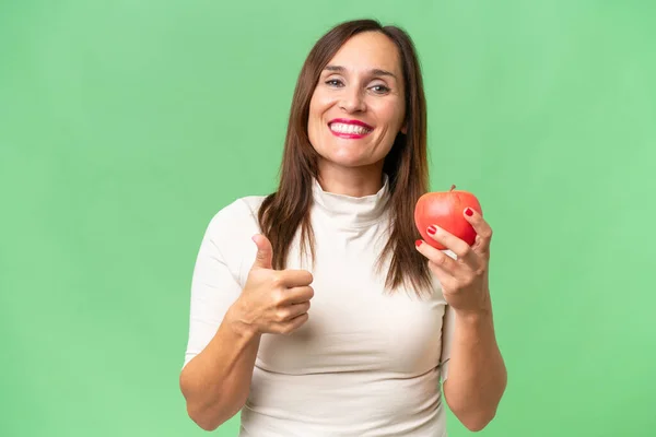 Kaukasische Frau Mittleren Alters Isoliert Auf Grünem Hintergrund Mit Apfel — Stockfoto