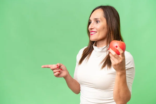 Kaukasische Frau Mittleren Alters Isoliert Auf Grünem Hintergrund Mit Apfel — Stockfoto