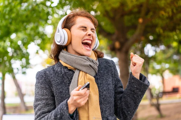 Μελαχρινή Γυναίκα Ακούγοντας Μουσική Ακουστικά Εξωτερικούς Χώρους Τηλέφωνο Στη Θέση — Φωτογραφία Αρχείου