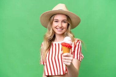 Young English woman with a cornet ice cream over isolated background with happy expression