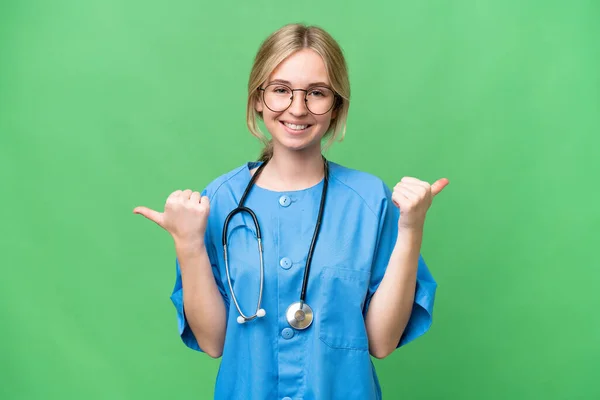 stock image Young nurse English woman over isolated background with thumbs up gesture and smiling