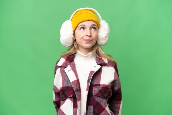 Νεαρή Αγγλίδα Που Φοράει Χειμωνιάτικες Μανσέτες Απομονωμένο Φόντο Και Κοιτάζει — Φωτογραφία Αρχείου