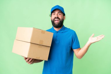 Teslimat beyaz adam izole edilmiş krom anahtar arka planda şok olmuş yüz ifadesi ile