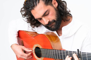 Young man with beard playing guitar on white background