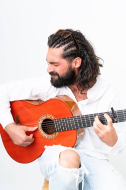 Young man with beard playing guitar on white background