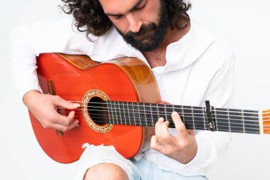 Young man with beard playing guitar on white background