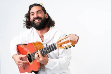 Young man with beard playing guitar on white background