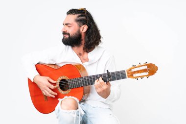 Young man with beard playing guitar on white background