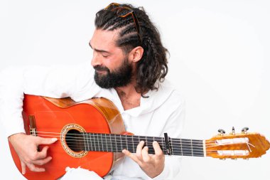 Young man with beard playing guitar on white background
