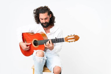 Young man with beard playing guitar on white background