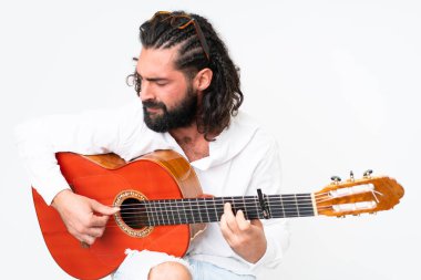 Young man with beard playing guitar on white background
