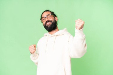 Young man with beard over isolated chroma key background celebrating a victory