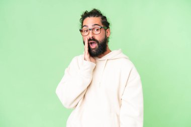 Sakallı genç adam izole edilmiş bir krom anahtar üzerinde yan tarafa bakarken sürpriz bir hareketle bir şeyler fısıldıyor.