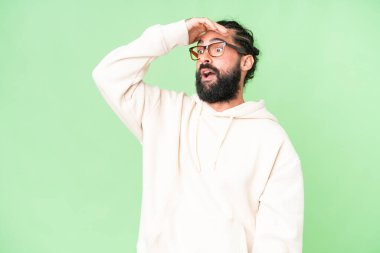 Sakallı genç adam izole edilmiş krom anahtar geçmişi var. Yan tarafa bakarken sürpriz jest yapıyor.